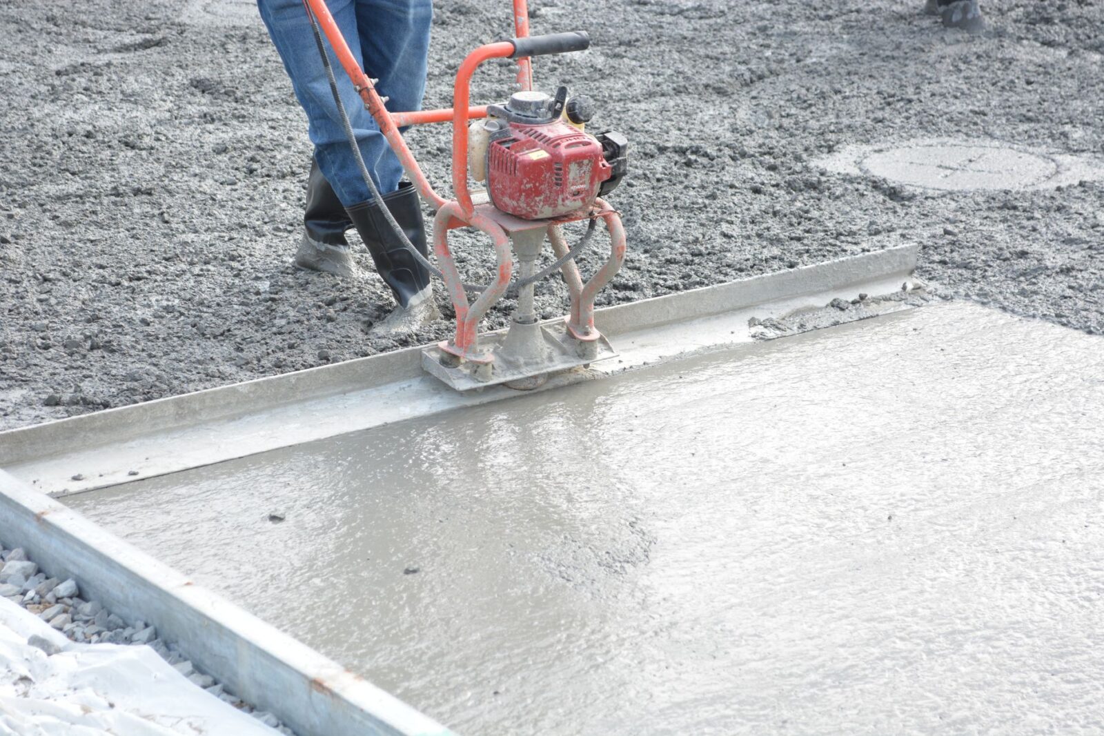 Ouvrier lissant une dalle de béton à la machine