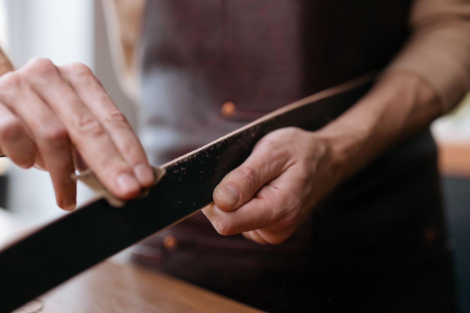 Mains ponçant une lame de bois au papier de verre